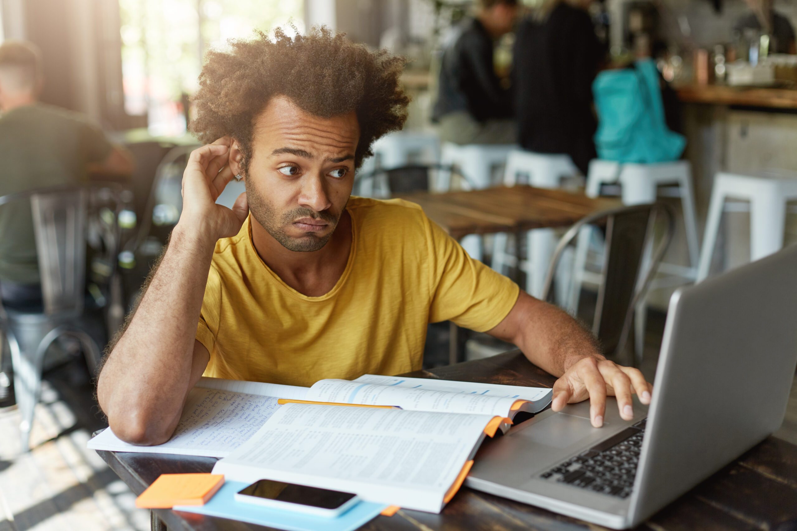 stylish-student-with-african-hairstyle-having-doubtful-look-while-looking-laptop-computer-understanding-new-material-trying-find-good-explanation-internet-1-scaled